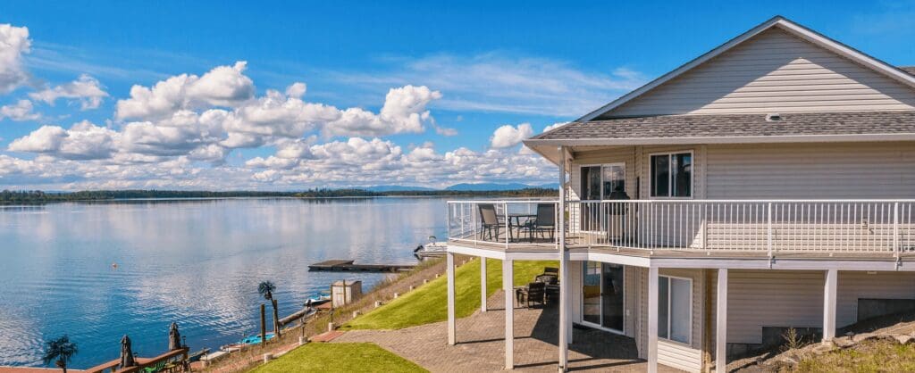 Lakeside house with scenic view and clouds.