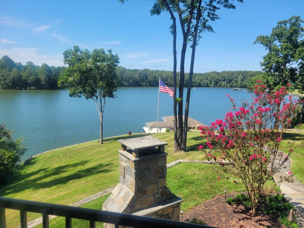 Lakeside view with trees and American flag.