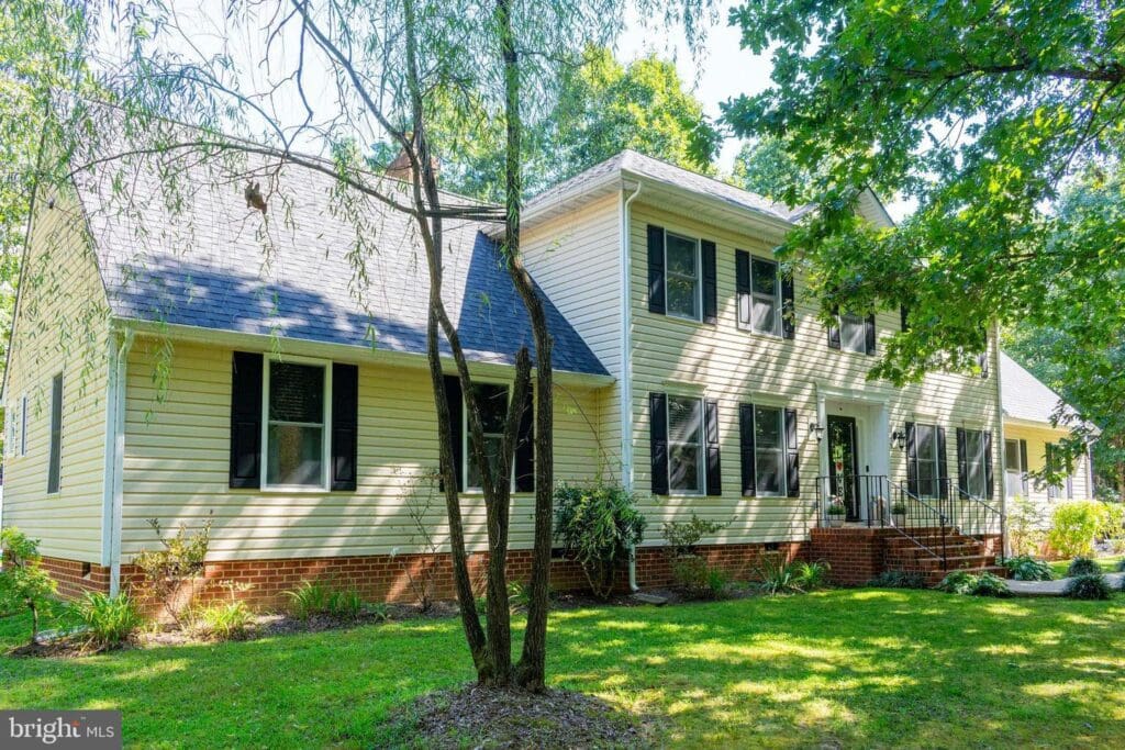Two-story house with trees and lawn.